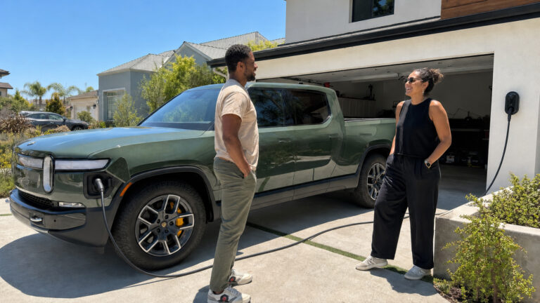rivian charging in front of home while two people of color converse