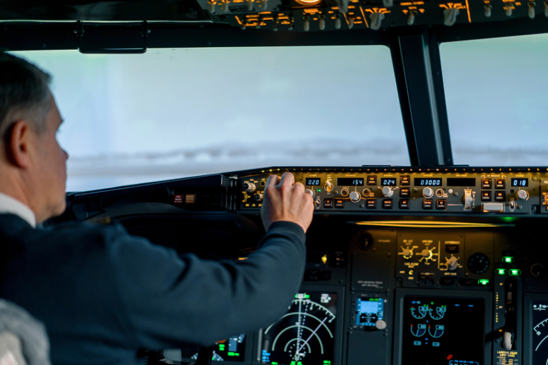 Pilot setting the autopilot in a cockpit, with nothing but haze visible through the windshield.